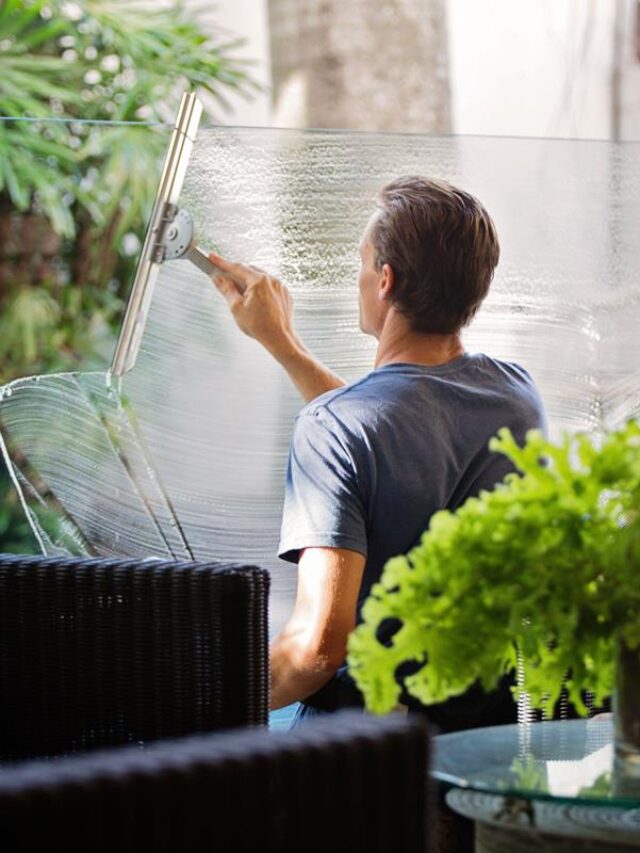 guy cleaning a glass structure in a office setting