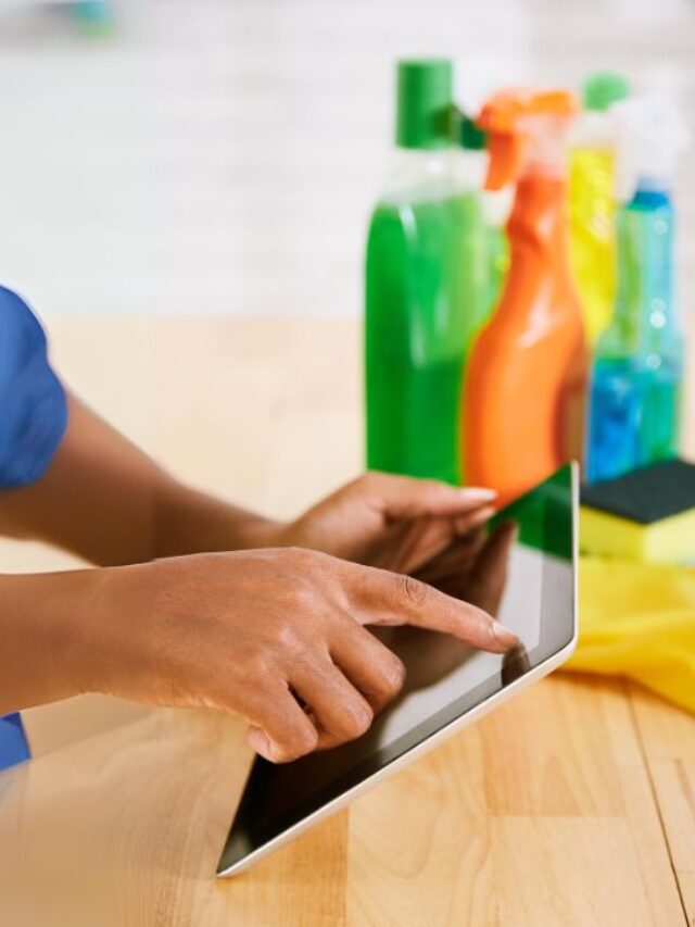 woman wearing a janitorial staff uniform looking in an ipad cleaning app