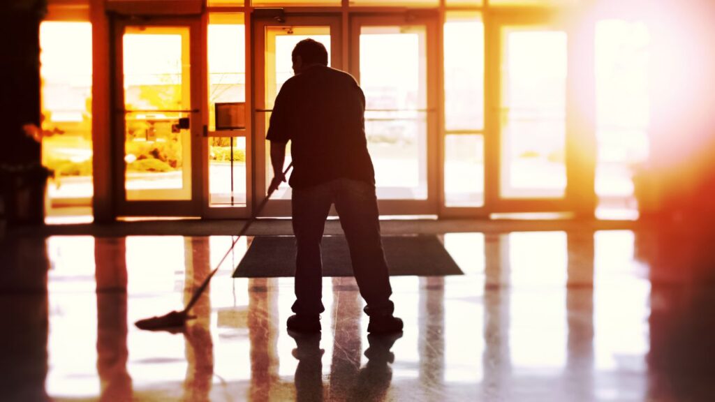 a man mopping a hard floor in a event center