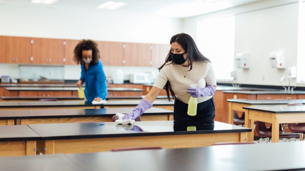two women cleaning a school lab