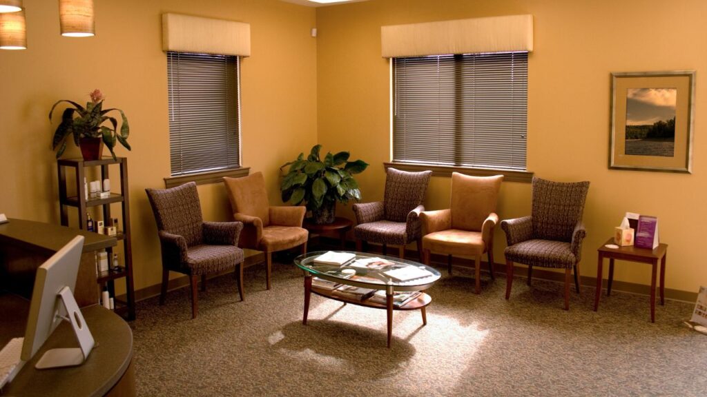 picture of a common area with a few chairs, a desk and a coffee table in the center of the chairs