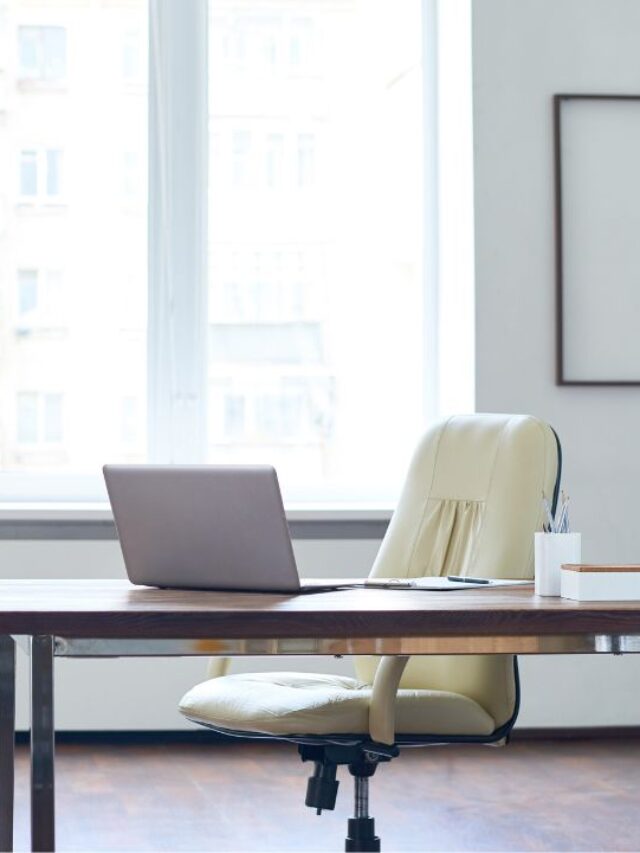 a clean and de-clutter office space with a white chair, desk, walls and curtains and a small plant to the side