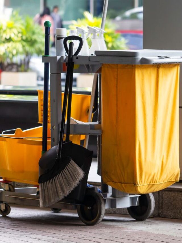 janitorial cleaning services cart with a mop, cation sign, broom and cleaning products to prevent falls