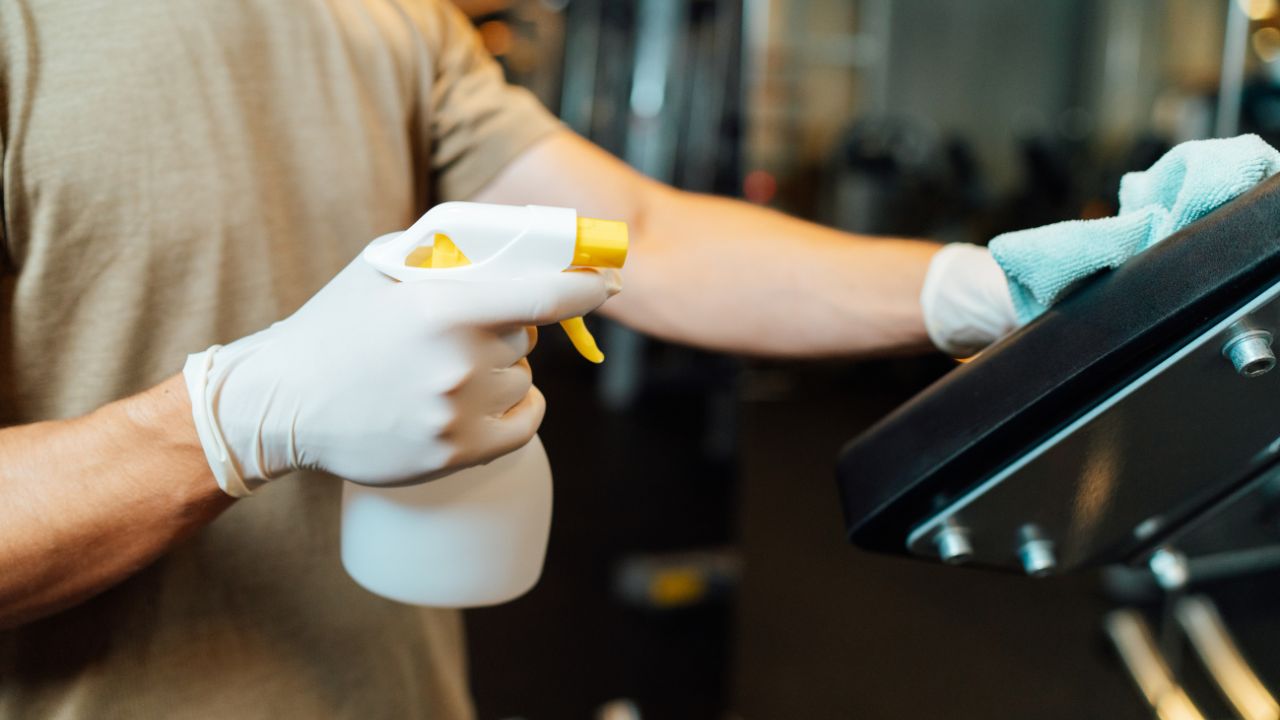 guy wiping down gym equipment