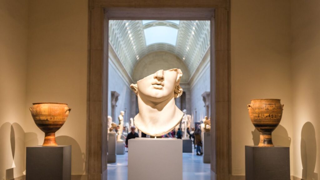 image of an art museum exibition with focus on a broken head statue and two vases