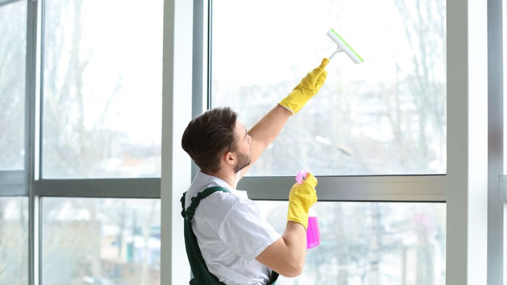 male cleaning staff cleaning out windows 