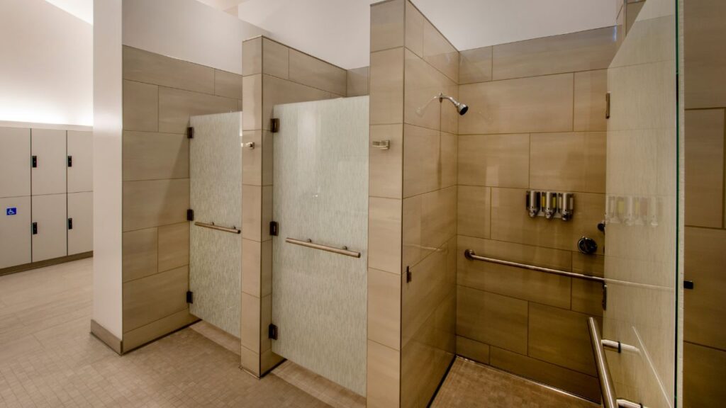 image of a gym locker room with three shower stalls