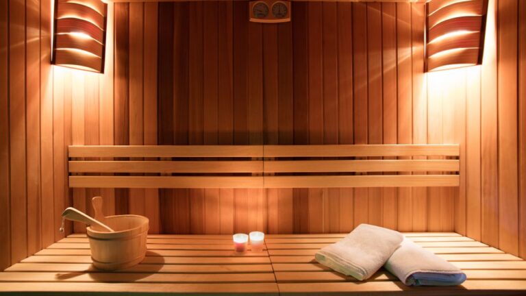 image of a wooden sauna with bench, bucket and towels for wellness clinic cleaning tips