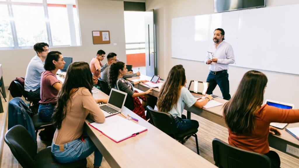 university classroom qith students sitting down and a professor up front