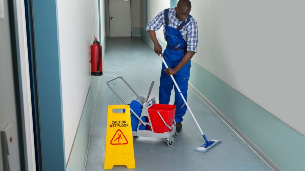 man mopping floor in a hallway